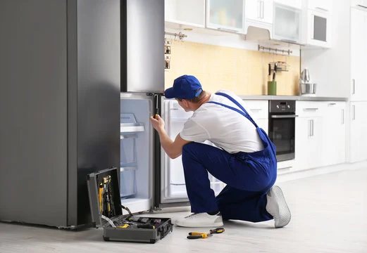 Technician checking the lower compartment of a refrigerator